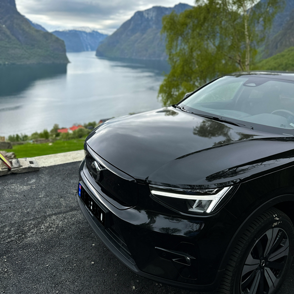 sort volvo c40 parkert ved en fjord 